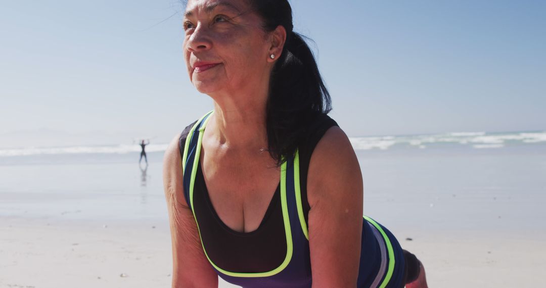 Middle-Aged Woman Exercising on Beach in Athletic Wear - Free Images, Stock Photos and Pictures on Pikwizard.com