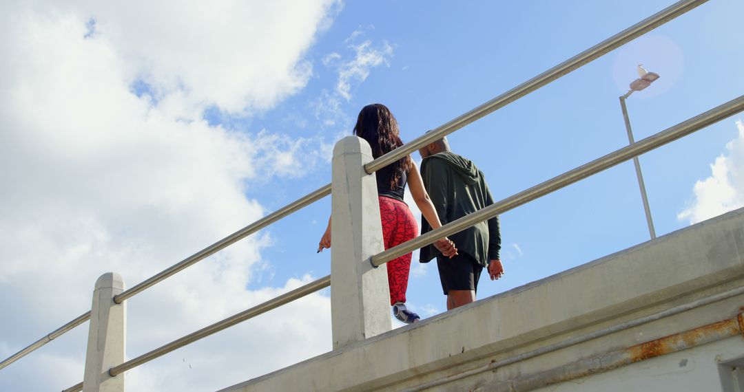 Couple Walking on Bridge with Blue Sky and Clouds - Free Images, Stock Photos and Pictures on Pikwizard.com