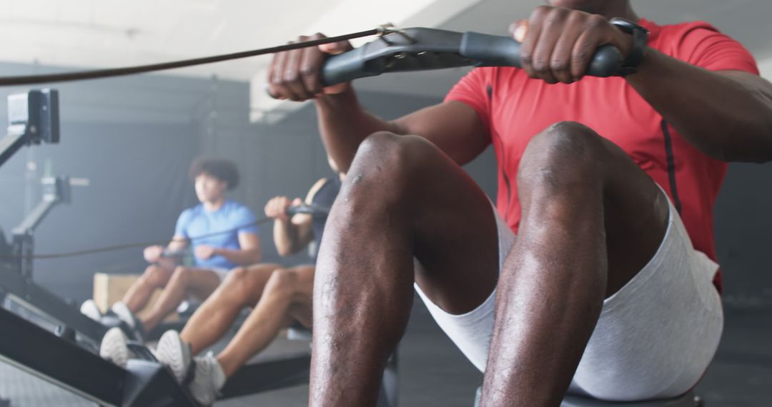 Diverse Group Exercising on Rowing Machines in Gym