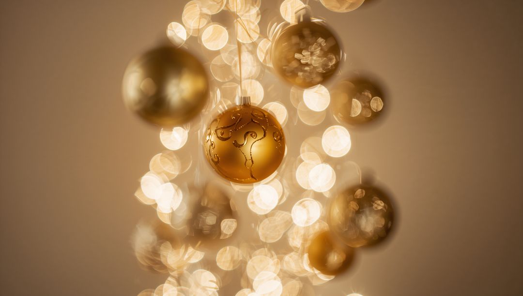 Ornate Gold Holiday Bauble Hanging with Etched Swirls and Soft Warm Bokeh Glow