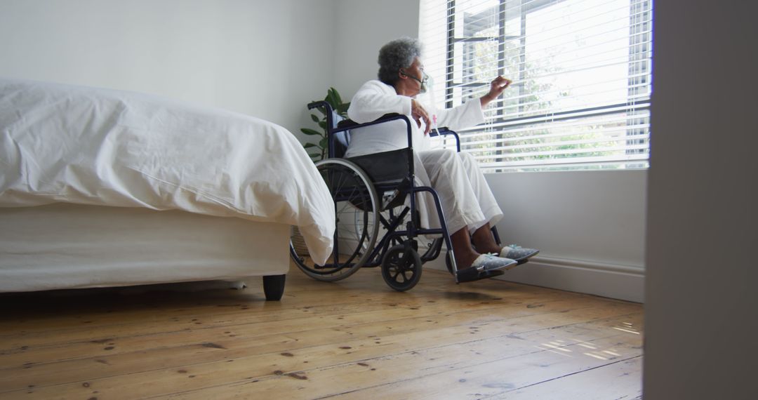 Elderly Person in Wheelchair Looking Out Window in Sunlit Room - Free Images, Stock Photos and Pictures on Pikwizard.com