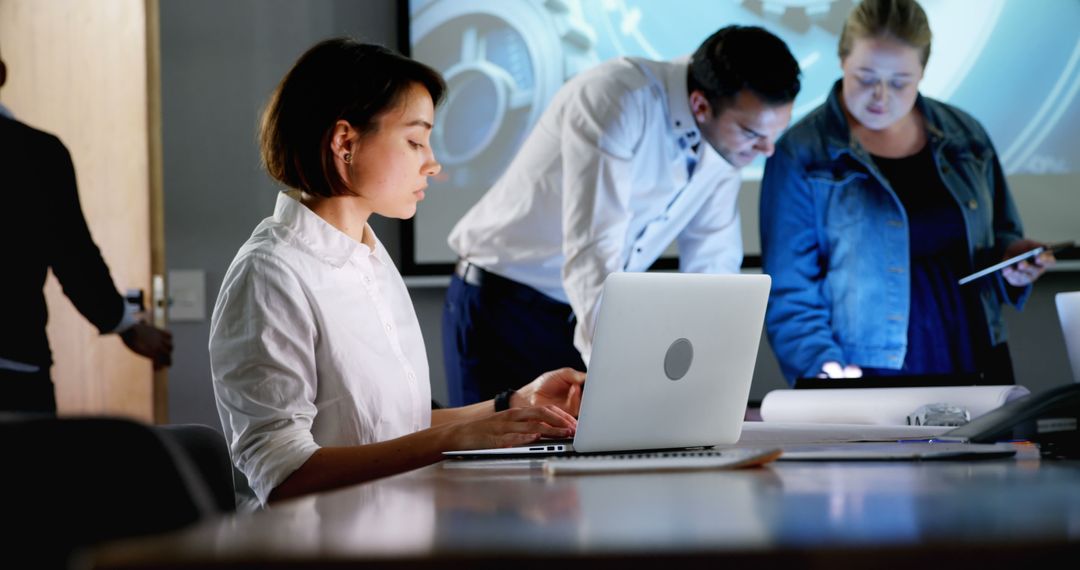 Focused Businesswoman Working on Laptop in Collaborative Office