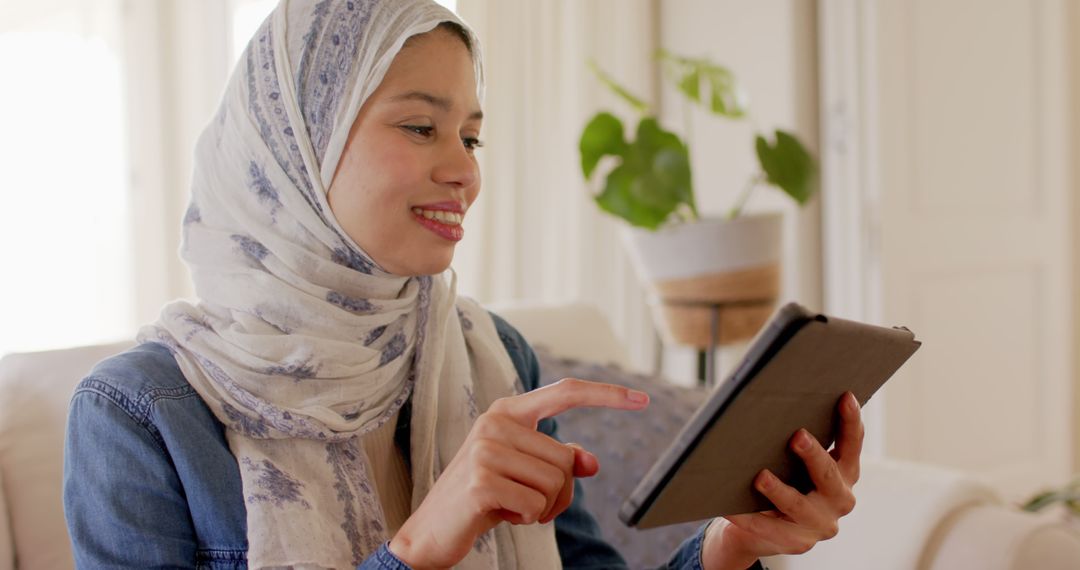 Smiling Woman in Hijab Using Tablet for Communication - Free Images, Stock Photos and Pictures on Pikwizard.com