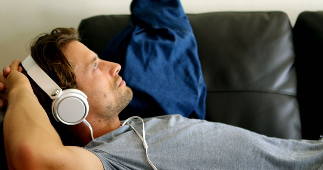 Relaxed Man Listening to Music with Headphones on Couch - Free Images, Stock Photos and Pictures on Pikwizard.com