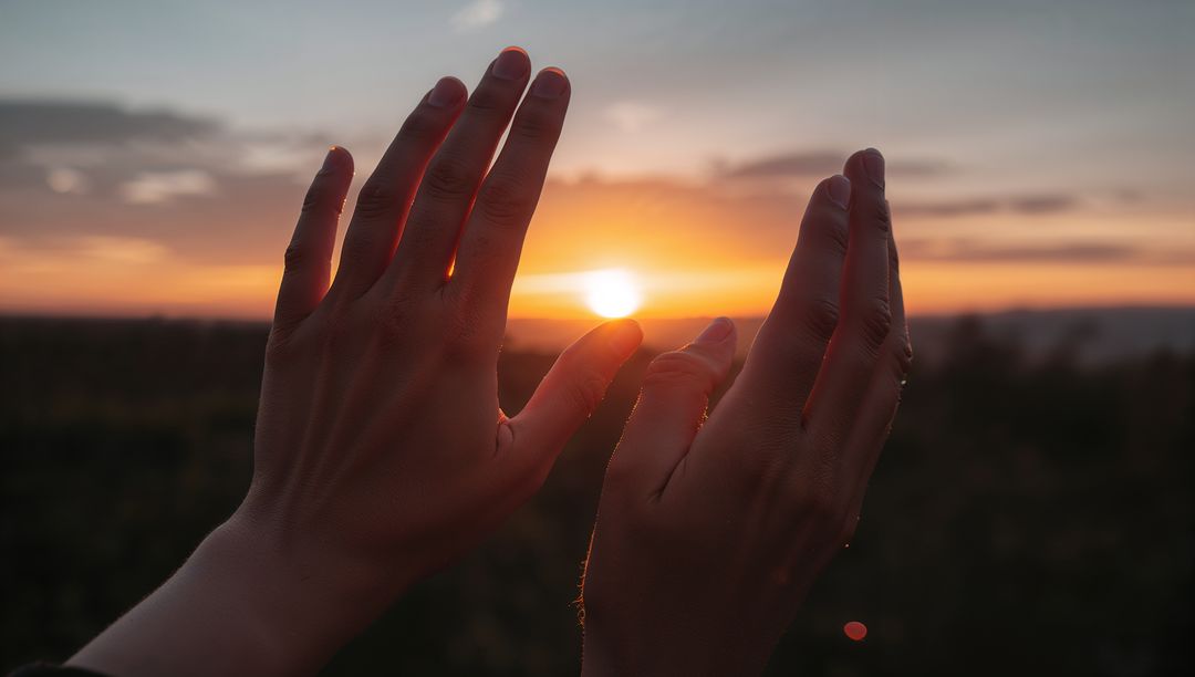 Cupping Sun at Sunset with Backlit Hands Framing Horizon and Golden Glow