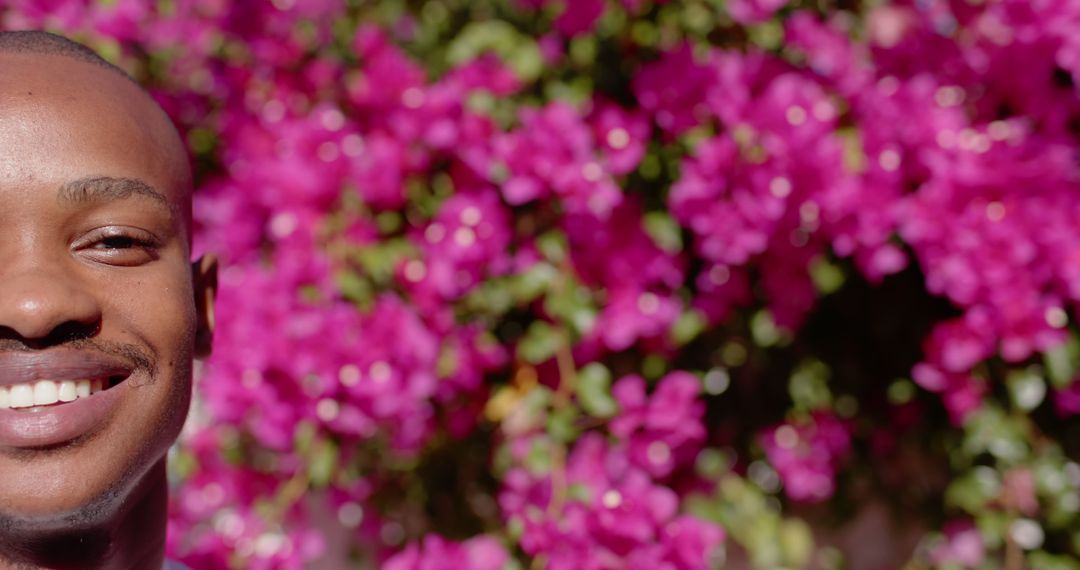 Smiling Young Man with Floral Background - Free Images, Stock Photos and Pictures on Pikwizard.com