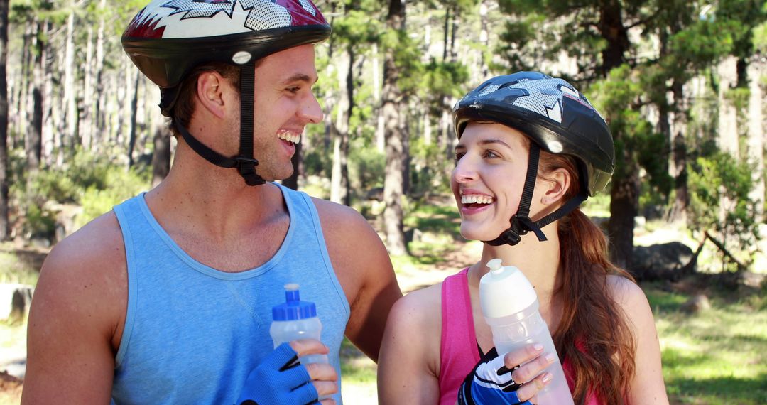 Smiling Cyclists on Outdoor Adventure with Water Bottles