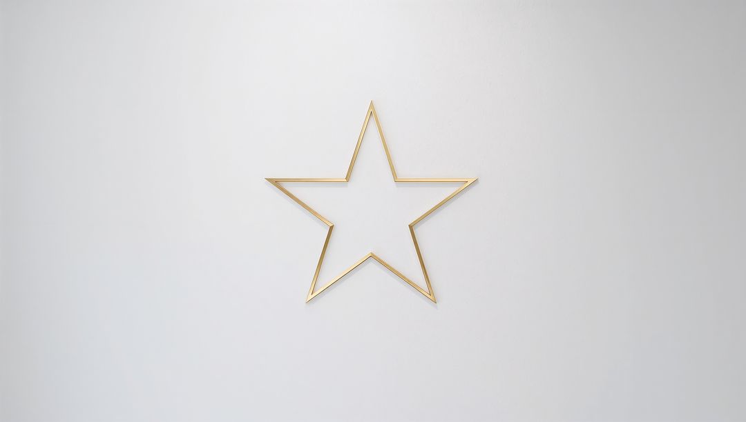 Hanging gold metal five-point star outline on smooth light gray wall with soft shadow