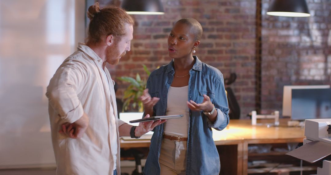 Diverse Team Discussing Project Details with Digital Tablet in Modern Office