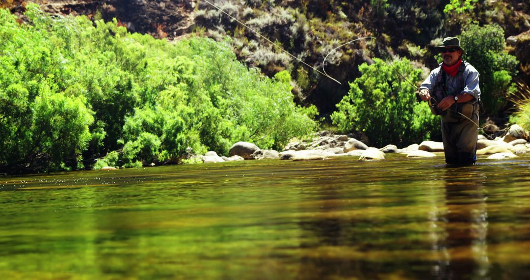 Man Fly Fishing in Tranquil River Surrounded by Lush Greenery - Free Images, Stock Photos and Pictures on Pikwizard.com