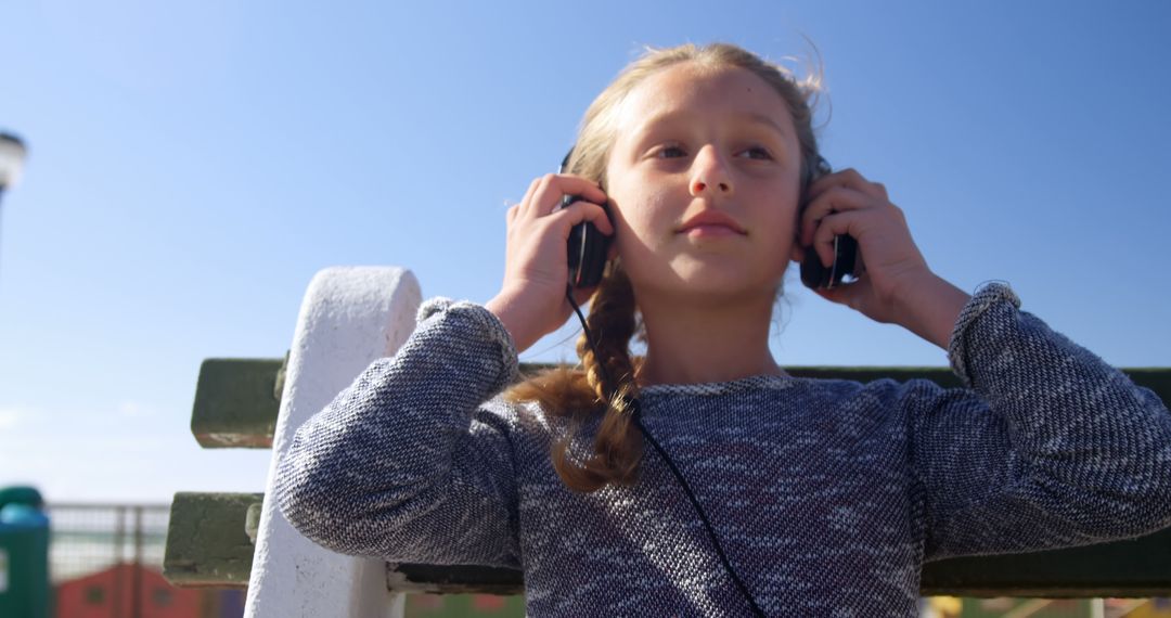 Young Girl Enjoying Music on Sunny Day Outdoors - Free Images, Stock Photos and Pictures on Pikwizard.com