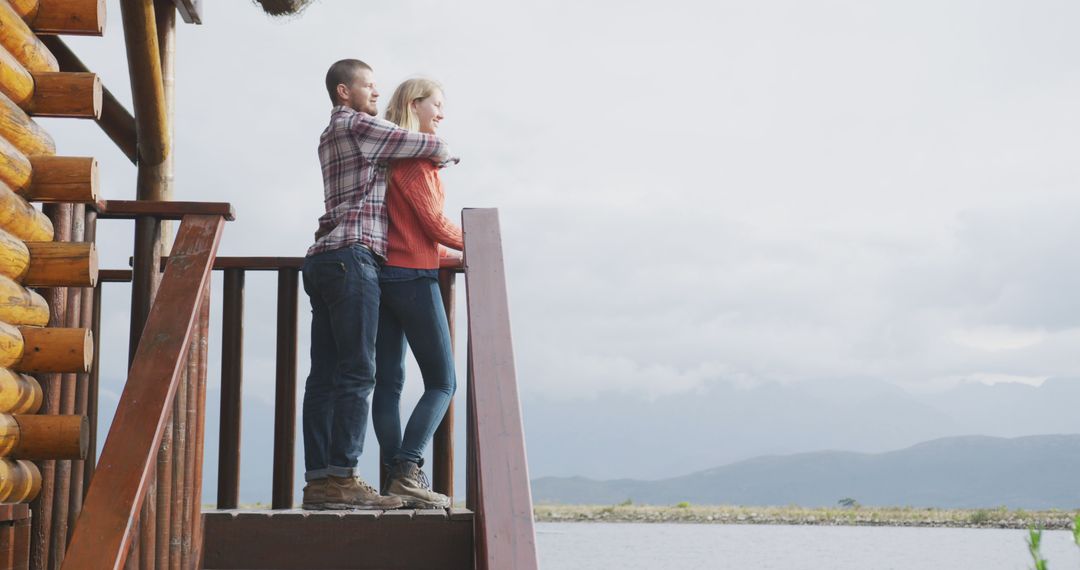 Couple Embracing on Cabin Balcony Overlooking Lake - Free Images, Stock Photos and Pictures on Pikwizard.com