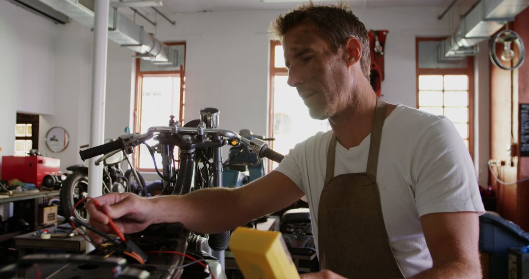 Caucasian male mechanic fixing motor bike in workshop, unaltered - Free Images, Stock Photos and Pictures on Pikwizard.com