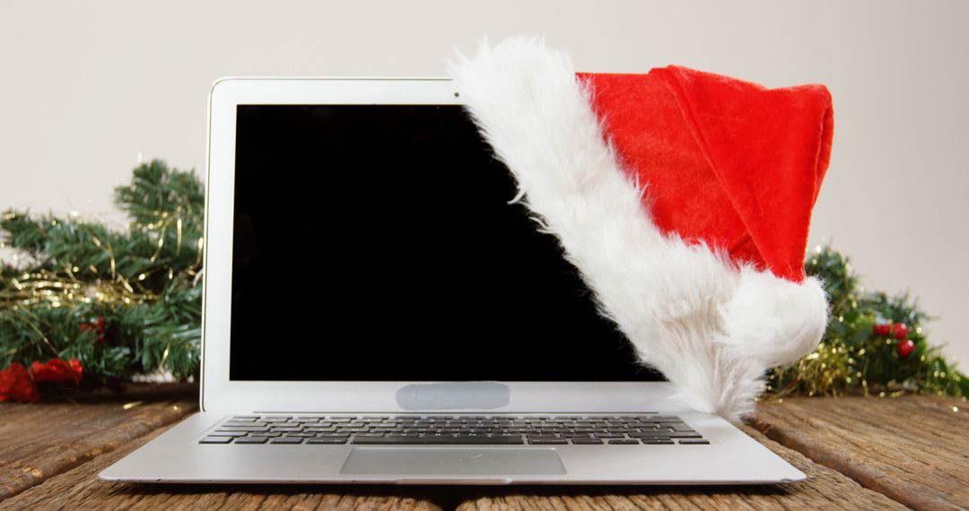 Laptop with Santa Hat Suggesting Holiday Season Greetings - Free Images, Stock Photos and Pictures on Pikwizard.com