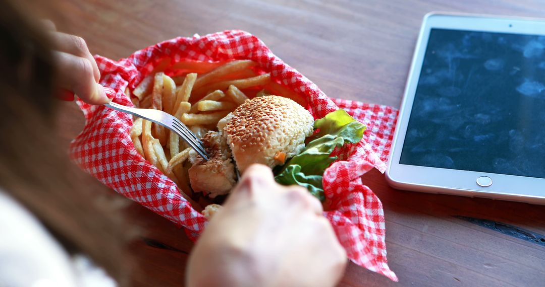 Close-up of a woman cutting burger with fork and knife in a restaurant - Free Images, Stock Photos and Pictures on Pikwizard.com