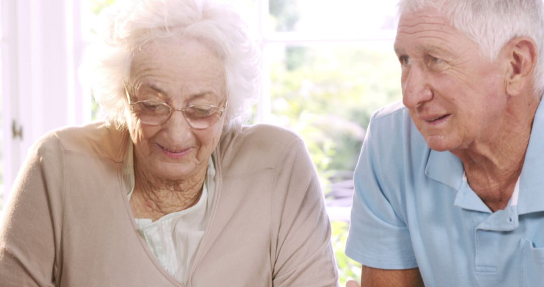 Senior Couple Reviewing and Signing Important Document