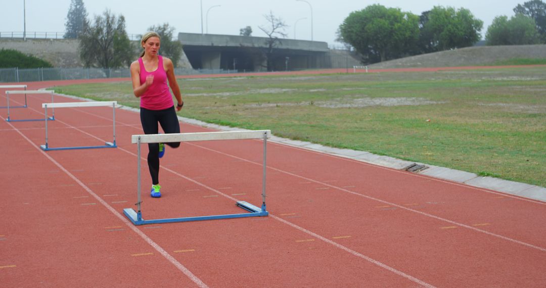 Female Athlete Training Hurdles on Outdoor Track Field - Free Images, Stock Photos and Pictures on Pikwizard.com