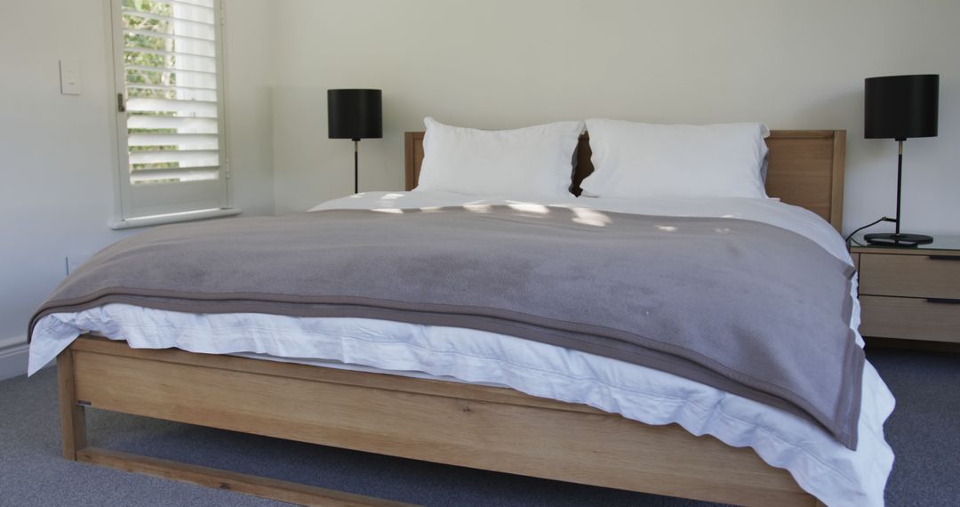 Modern Minimalist Bedroom with Wooden Bed and Black Lamps - Free Images, Stock Photos and Pictures on Pikwizard.com