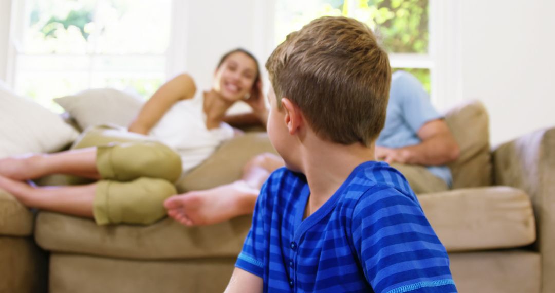 Young Boy Sitting on Floor at Home Watching Family Conversation - Free Images, Stock Photos and Pictures on Pikwizard.com