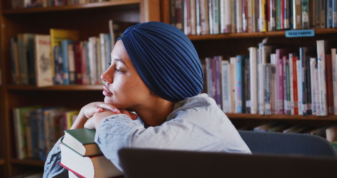 Thoughtful Woman with Turban in Library, Stack of Books on Desk - Free Images, Stock Photos and Pictures on Pikwizard.com