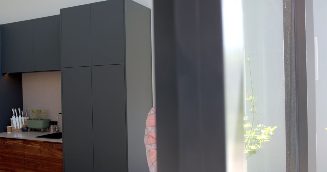 Man in Turban Using Smartphone Near Window at Home