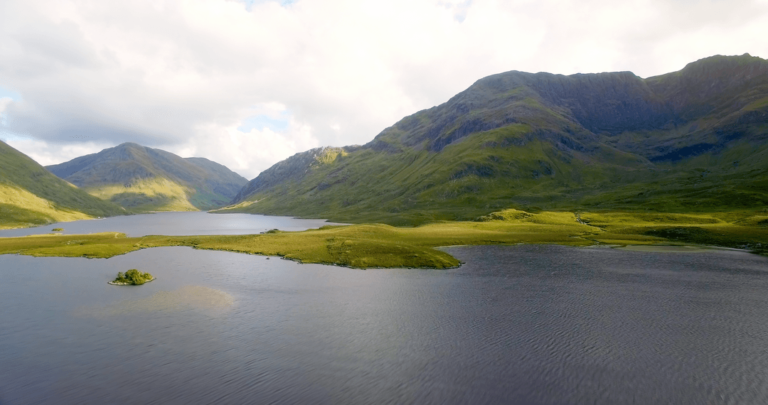 Transparent Lake Waters and Mountain Peaks under Clouded Sky