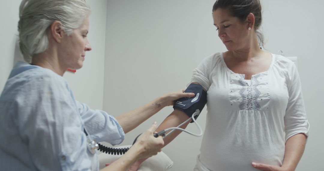 Medical Professional Taking Blood Pressure of Middle-Aged Female Patient - Free Images, Stock Photos and Pictures on Pikwizard.com