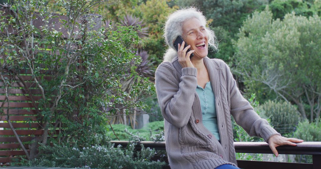 Elderly Woman Enjoying Phone Call in Garden, Smiling and Relaxing Outdoors - Free Images, Stock Photos and Pictures on Pikwizard.com