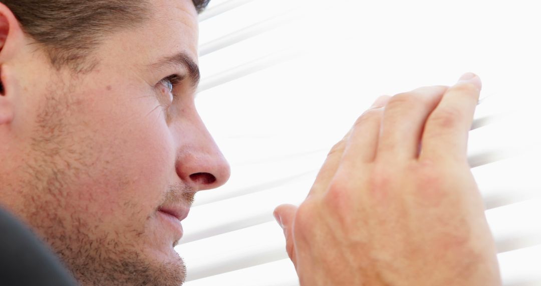 Curious Businessman Peeking Through Office Blinds