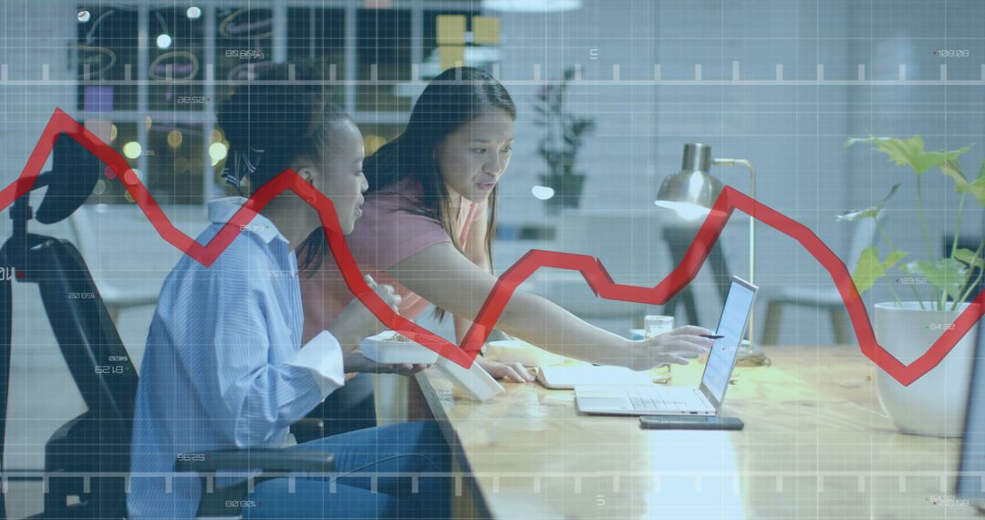 Businesswomen Analyzing Financial Data Trends on Computer