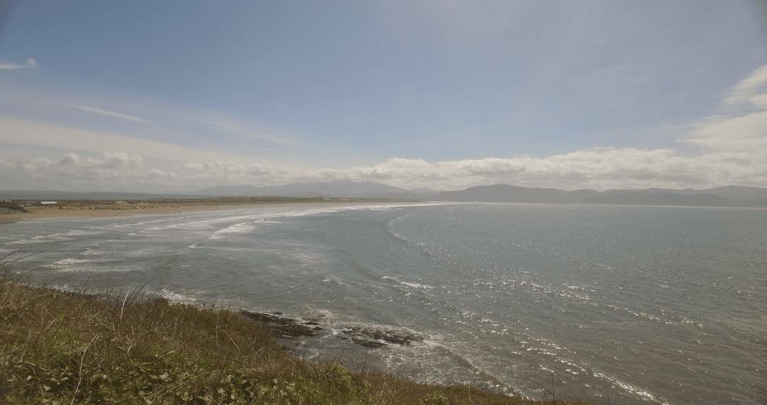 Transparent Waves Gently Hitting Idyllic Shoreline Under Cloudy Sky