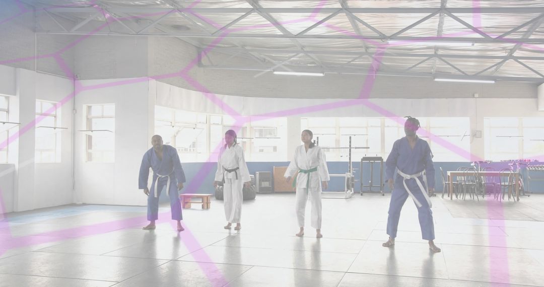 Four Martial Artists Practicing Stances in Bright Dojo Wearing Gis and Colored Belts