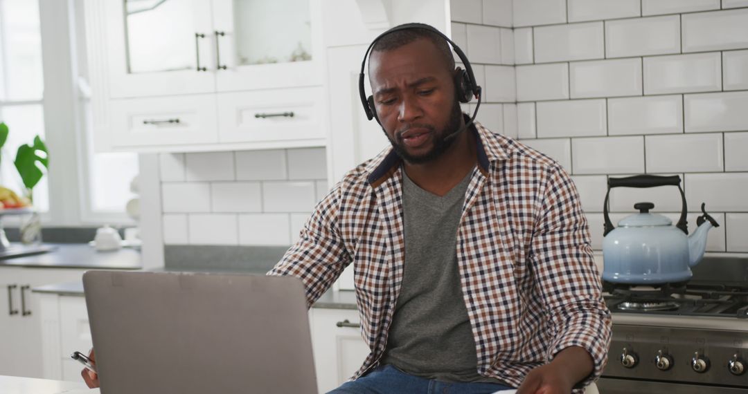 Man Wearing Headset Working from Home in Kitchen - Free Images, Stock Photos and Pictures on Pikwizard.com