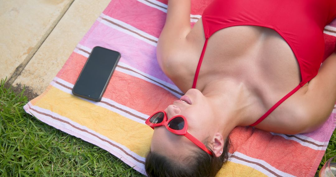 Woman Sunbathing Relaxing on Striped Towel with Smartphone
