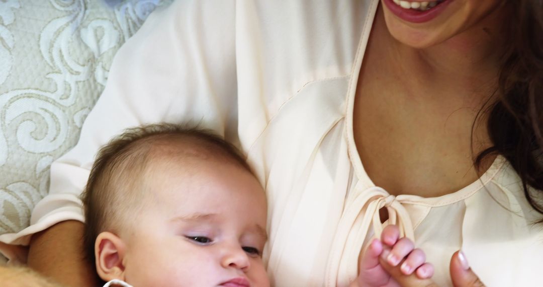 Smiling Mother Cuddling Baby on Couch - Free Images, Stock Photos and Pictures on Pikwizard.com