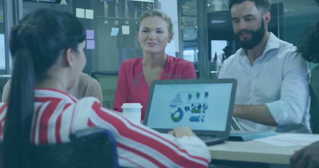 Multicultural Team Analyzing Financial Data on Laptop in Modern Office
