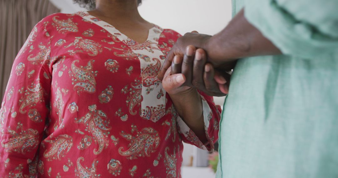 Elder Woman Holding Hands with Caregiver in Warm Living Room Setting - Free Images, Stock Photos and Pictures on Pikwizard.com