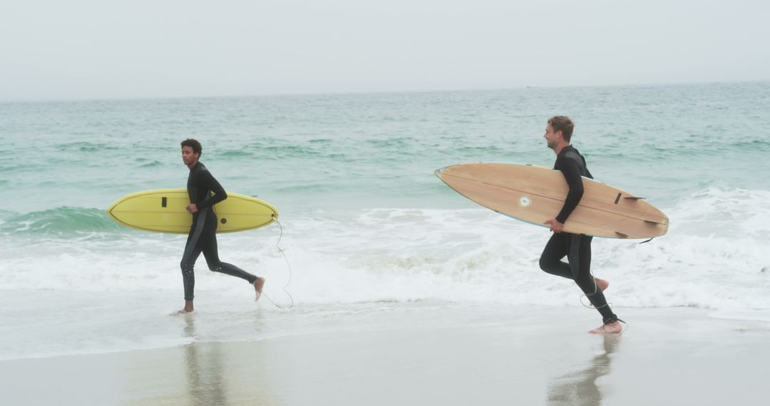 Energetic Surfers Running with Boards by Ocean Waves