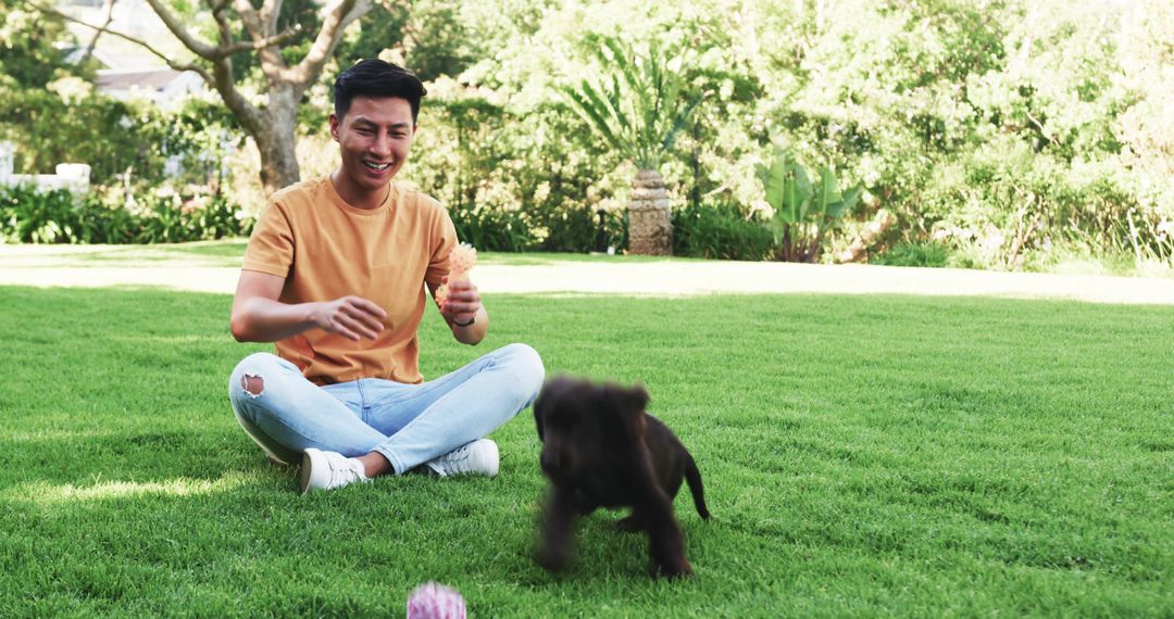 Man Playing with Puppy in Lush Garden Relaxed Journey of Joy
