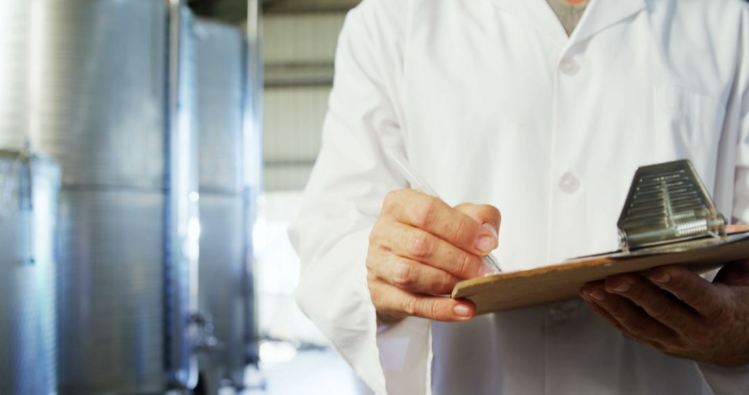 Quality Control Inspector Writing on Clipboard in Industrial Warehouse - Free Images, Stock Photos and Pictures on Pikwizard.com