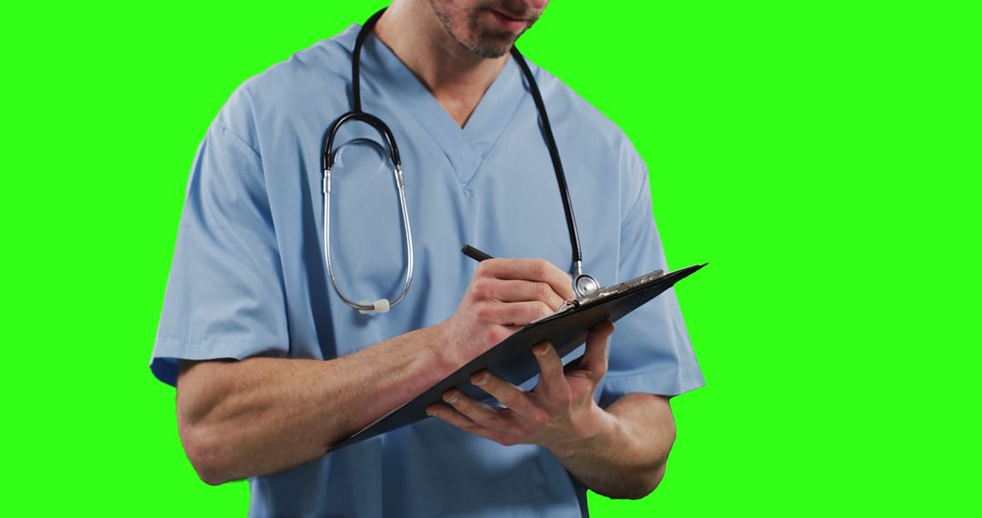 Male Doctor in Blue Scrubs Writing on Clipboard with Green Screen Background - Free Images, Stock Photos and Pictures on Pikwizard.com