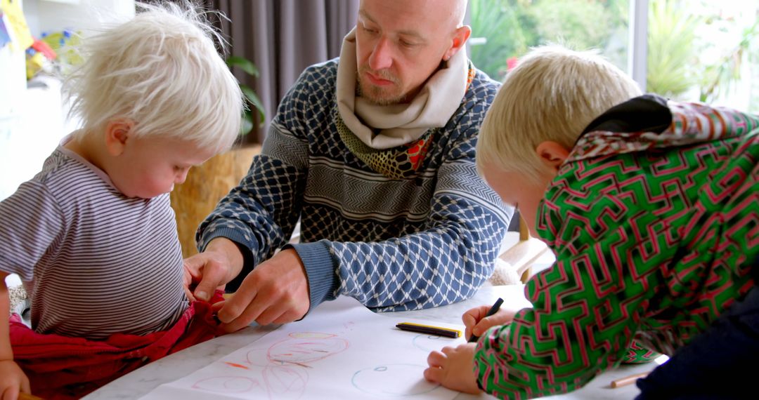 Father Assisting Child With Drawing at Family Table