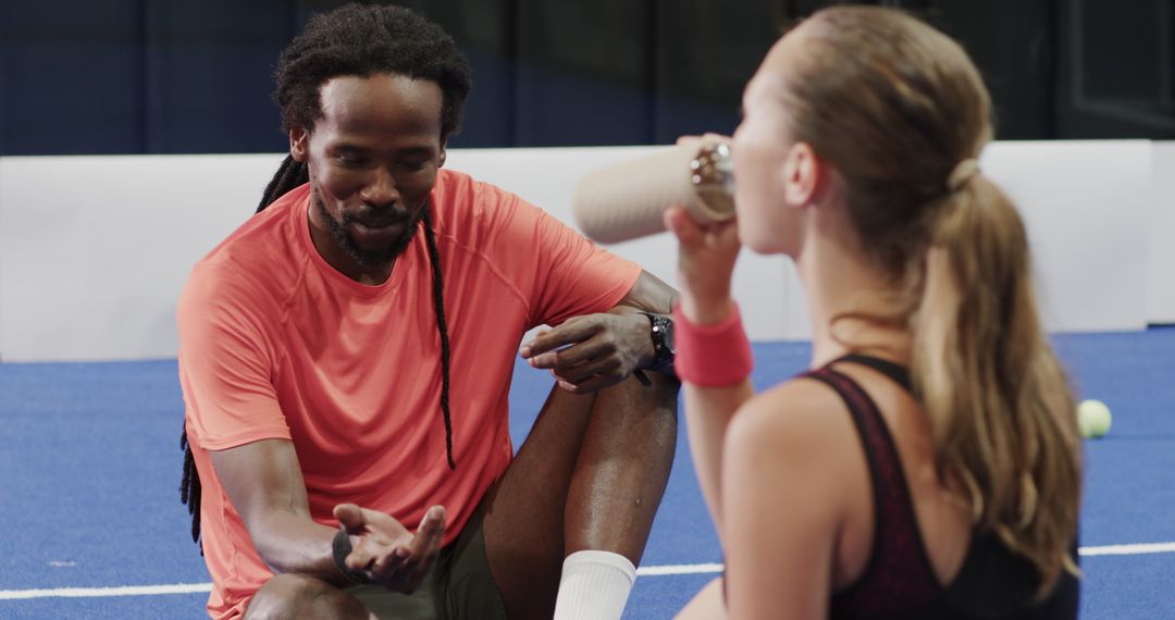 Coach Discussing Strategy with Padel Player During Break