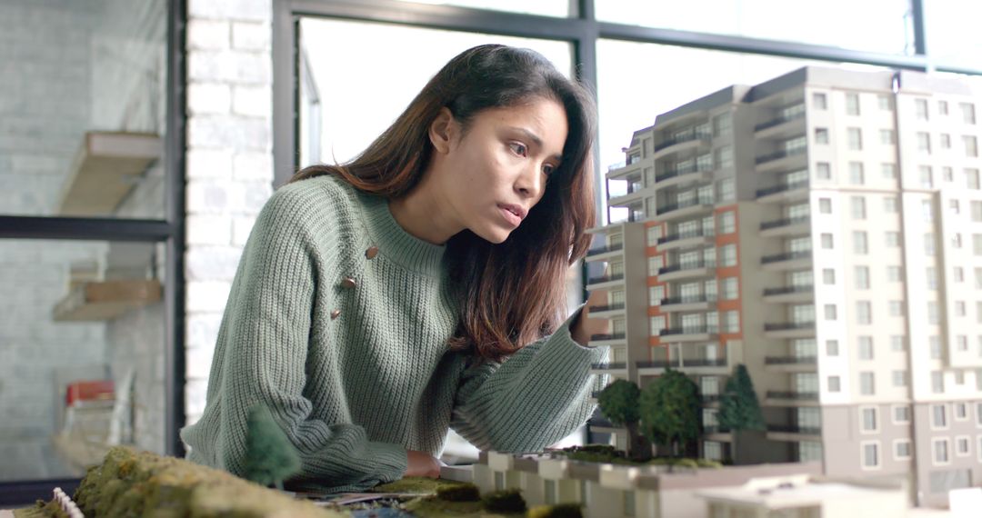 Female Architect Inspecting Building Model in Office - Free Images, Stock Photos and Pictures on Pikwizard.com