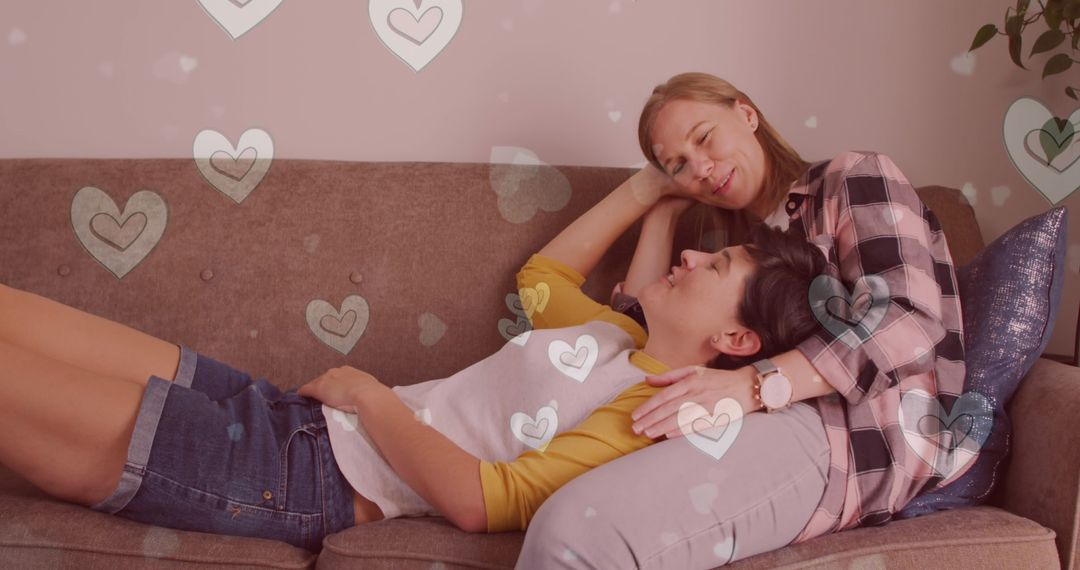Caucasian Female Couple Relaxing on Sofa with Floating Hearts