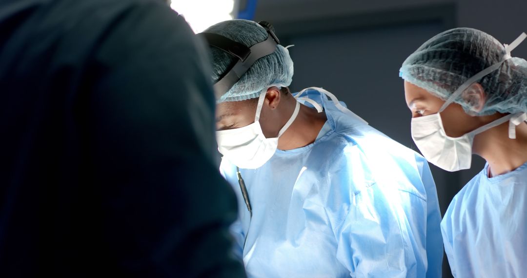 Diverse surgeons with face masks during surgery in operating room - Free Images, Stock Photos and Pictures on Pikwizard.com