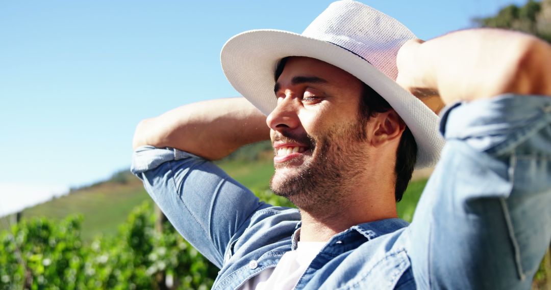 Relaxed Man Wearing Sunhat Enjoying Outdoors on Sunny Day - Free Images, Stock Photos and Pictures on Pikwizard.com