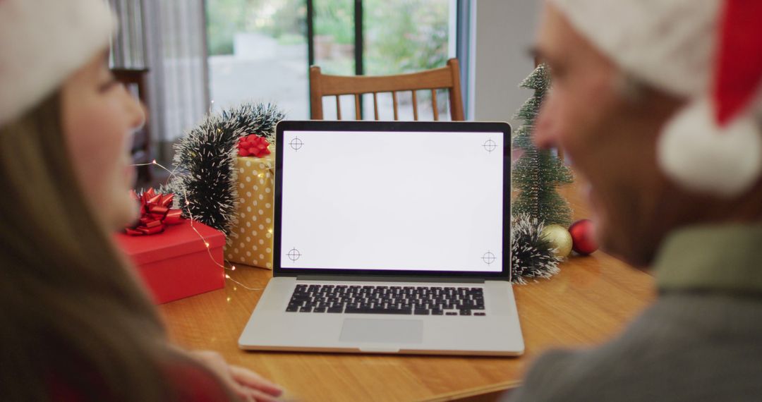 Couple with Santa Hats Celebrating Christmas Near Laptop with Blank Screen - Free Images, Stock Photos and Pictures on Pikwizard.com