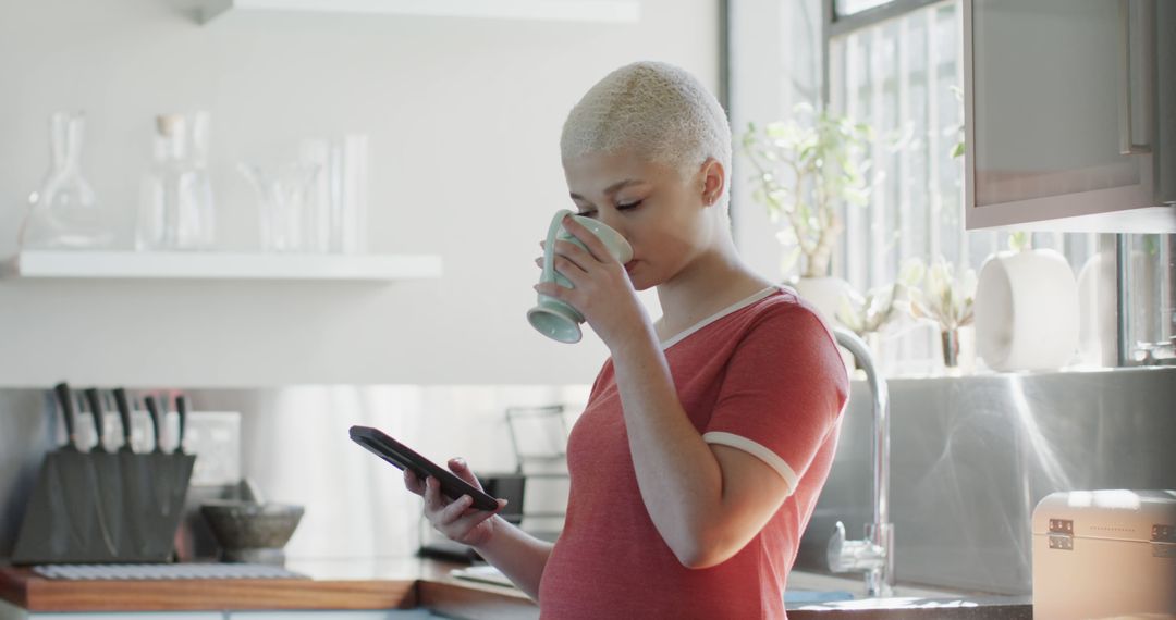 Pregnant woman drinking coffee while using tablet in modern kitchen - Free Images, Stock Photos and Pictures on Pikwizard.com