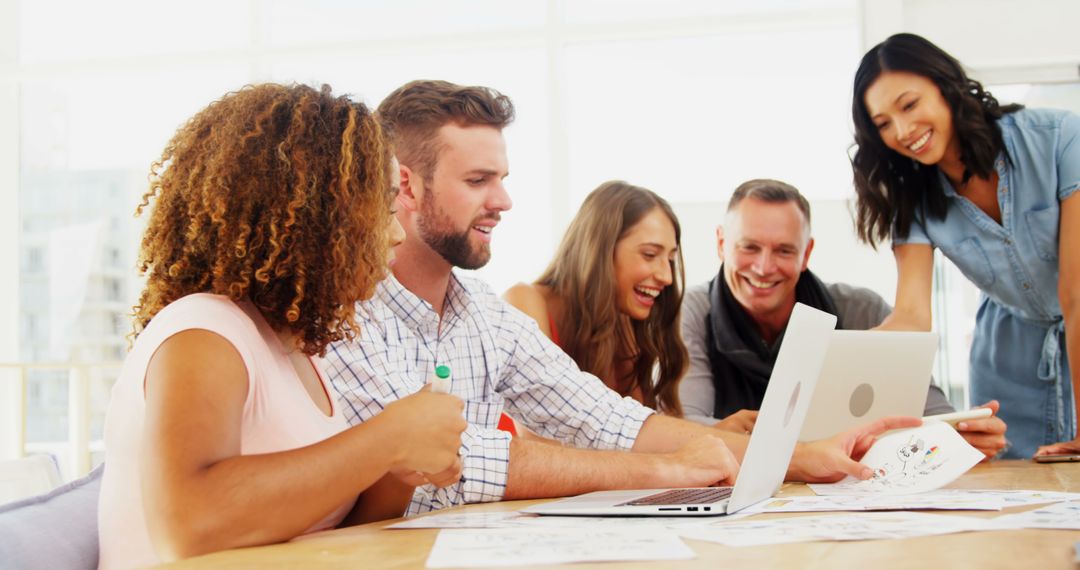 Diverse Professionals Engaged in Creative Brainstorming Session around Laptop